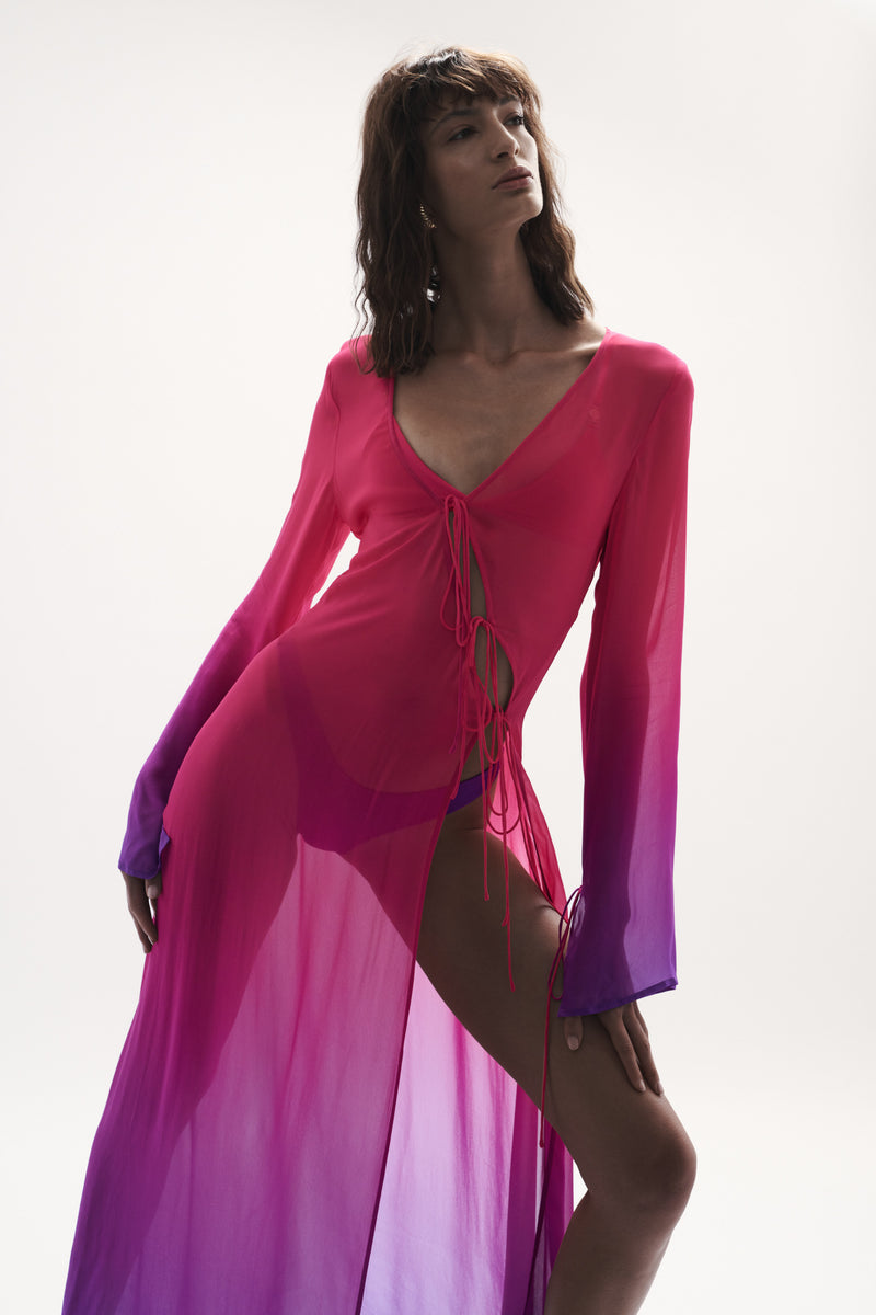 front enclined view elegant woman wearing luxury swimwear from sommer swim - pelicano berry crush is a pink and purple gradient robe dress