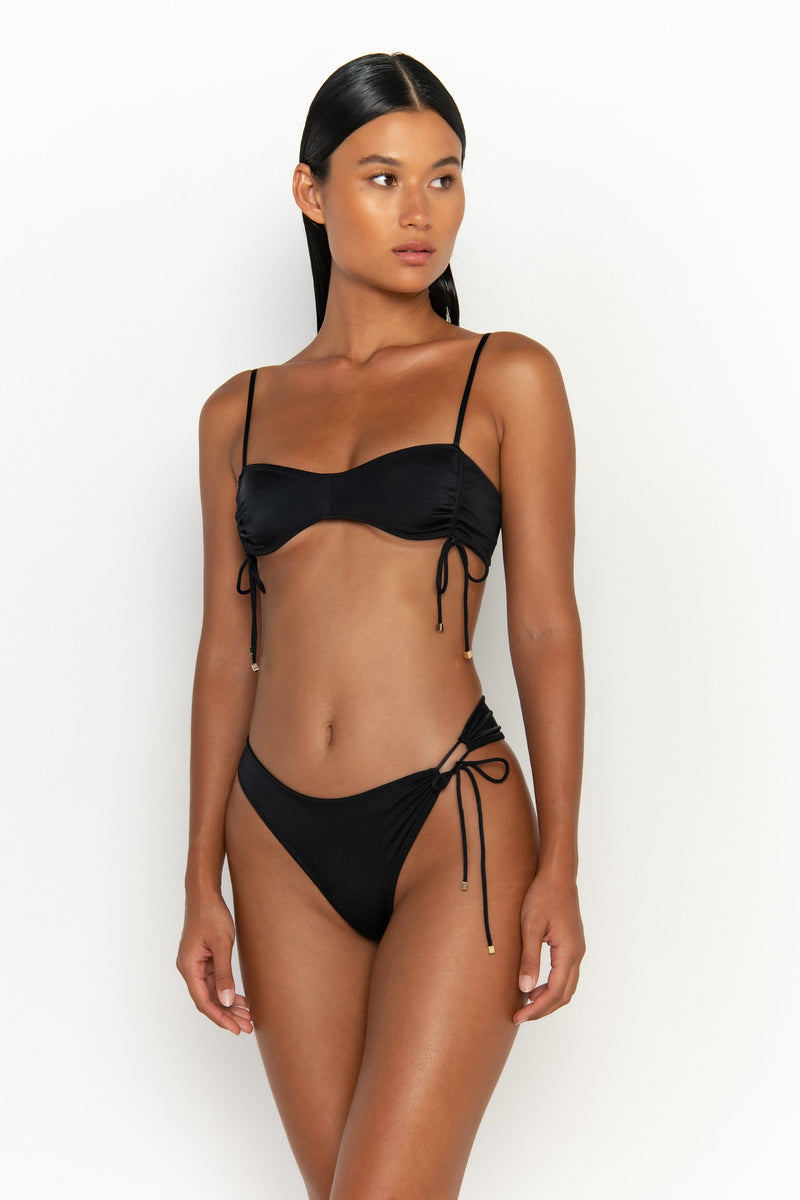 side view elegant woman wearing luxury swimsuit from sommer swim - bea nero is a black bikini with bralette bikini top