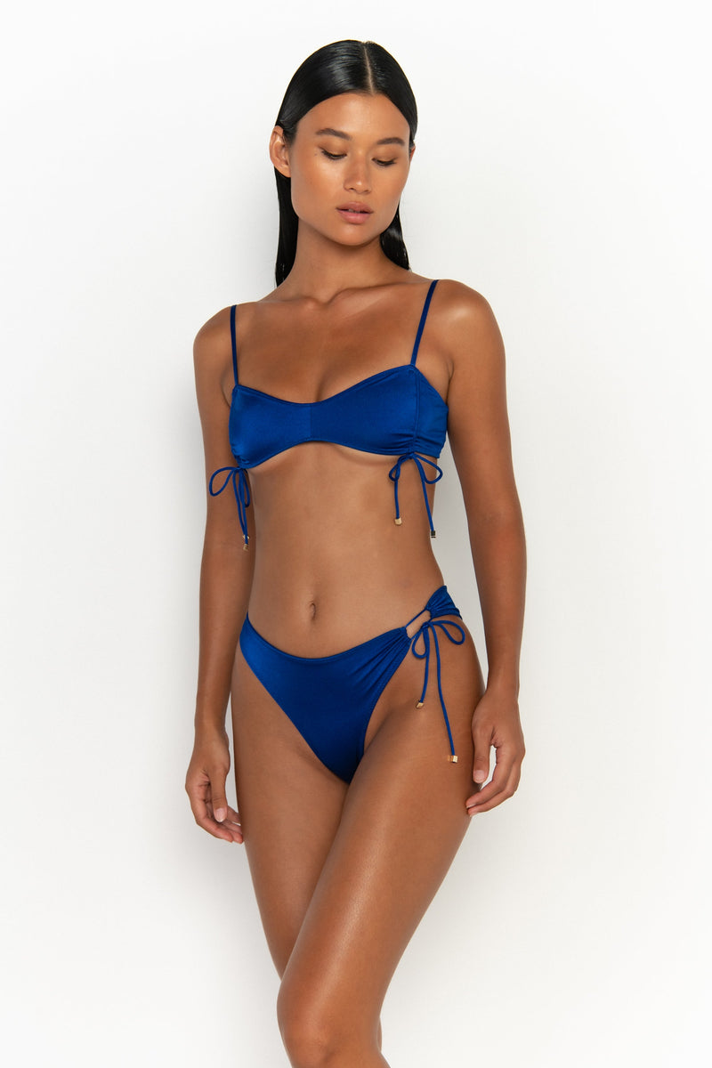 side view elegant woman wearing luxury swimsuit from sommer swim - bea olympus is a royal blue bikini with bralette bikini top