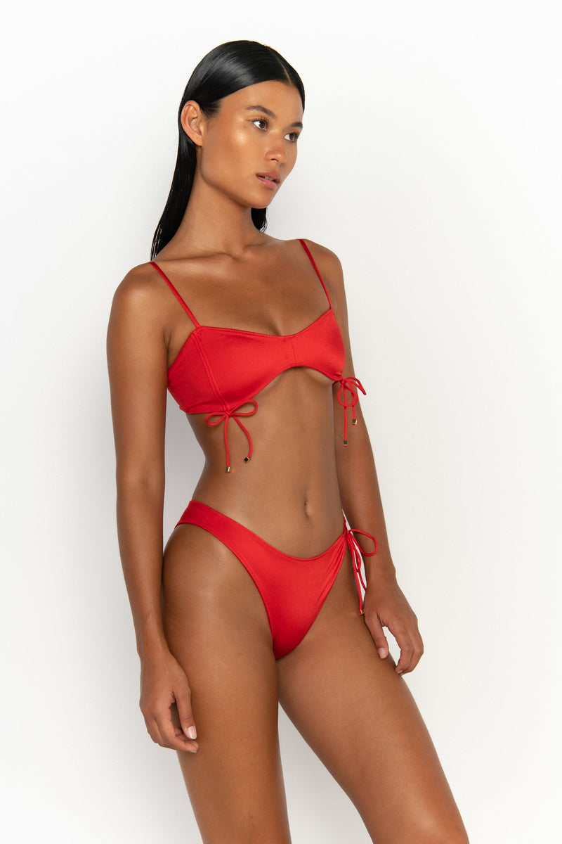 side view elegant woman wearing luxury swimsuit from sommer swim - bea siren is a red bikini with bralette bikini top
