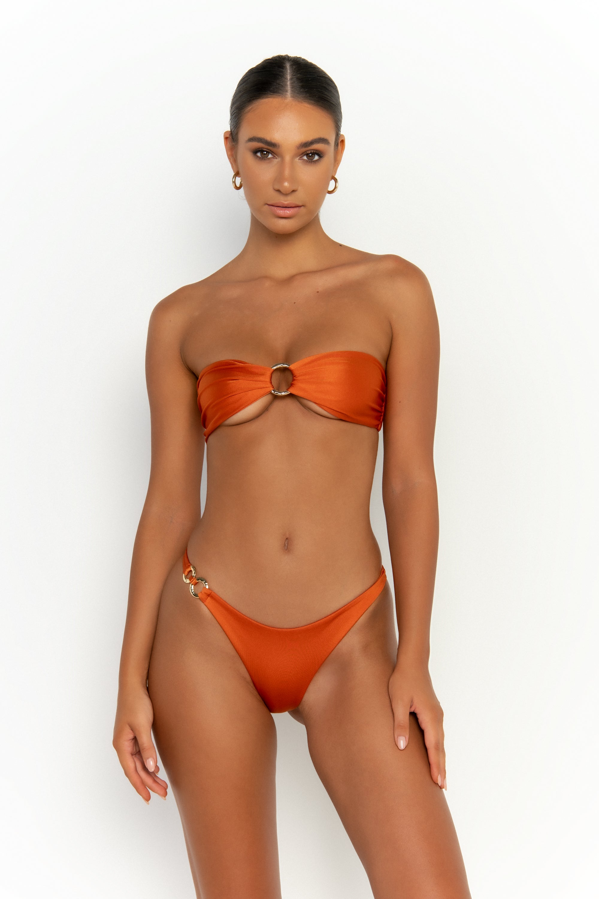 front view elegant woman wearing luxury swimsuit from sommer swim - cece egitto is a dark orange bikini with a bandeau bikini top