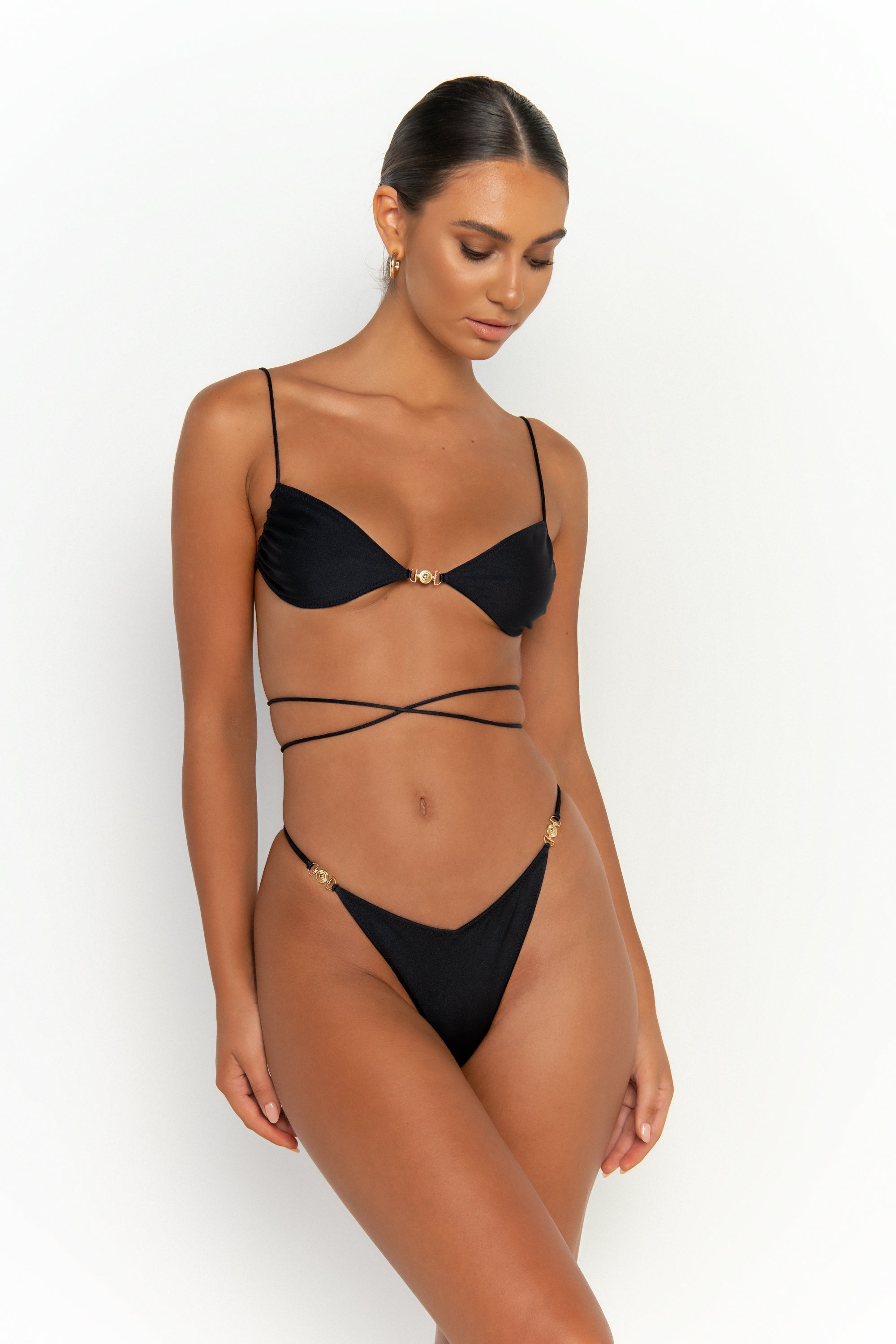 side view elegant woman wearing luxury swimsuit from sommer swim - ella nero is a black bikini with bralette bikini top