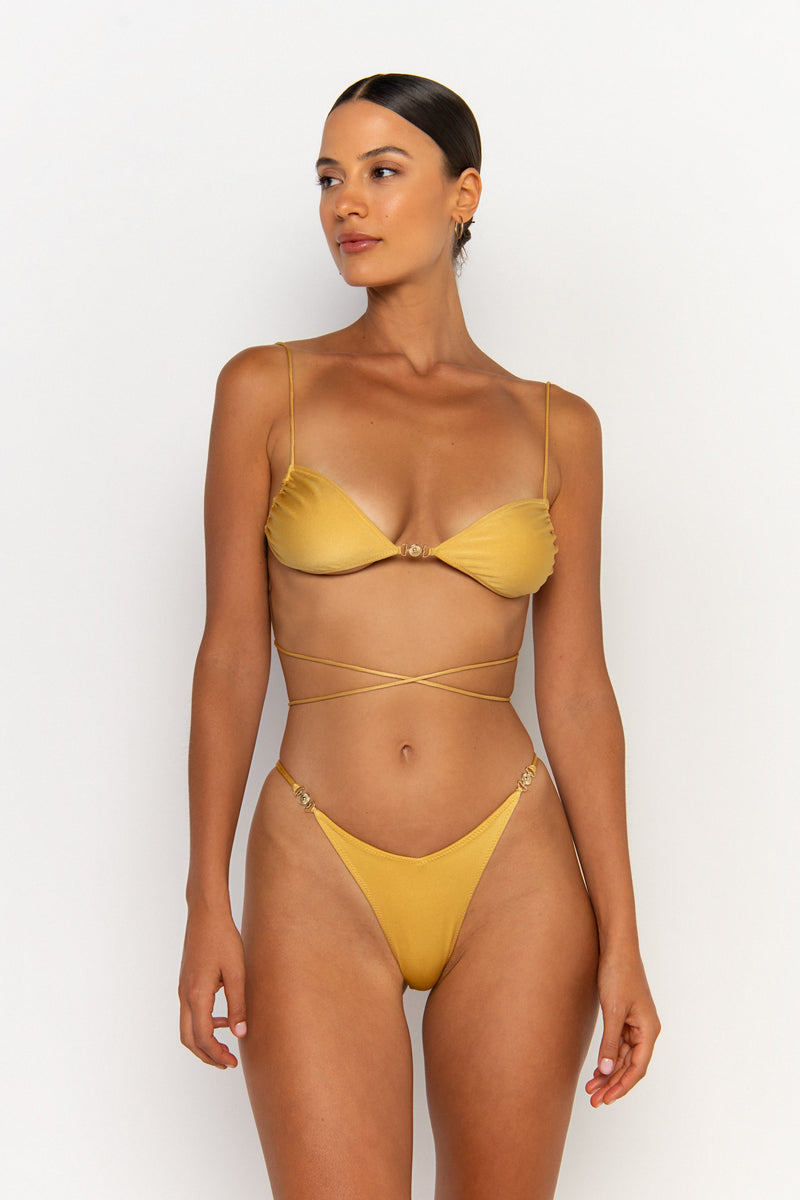front looking side view elegant woman wearing luxury swimsuit from sommer swim - ella lusso is a golden bikini with bralette bikini top