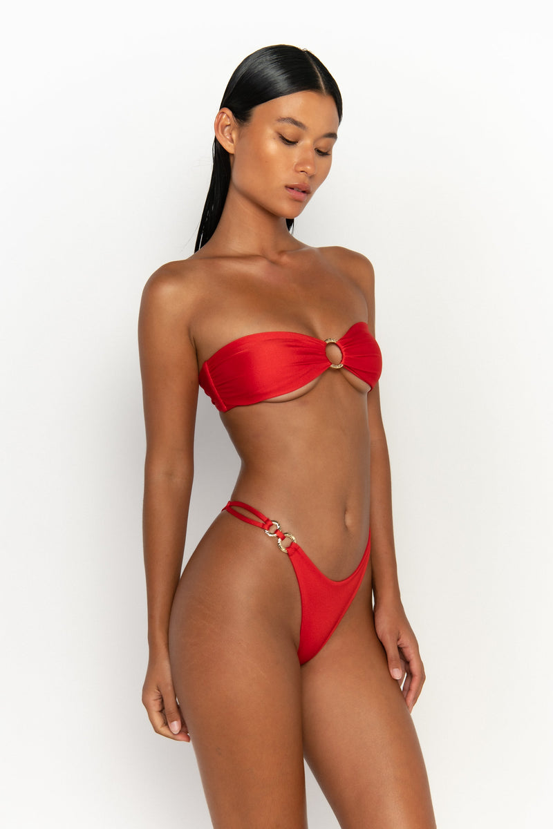 side view elegant woman wearing luxury swimsuit from sommer swim - cece siren is a red bikini with a bandeau bikini top