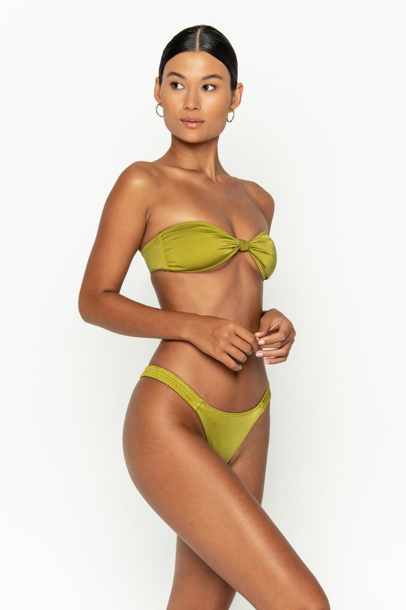 side view elegant woman wearing luxury swimsuit from sommer swim - iggy pascolo is a light green bikini with cheeky bikini bottom