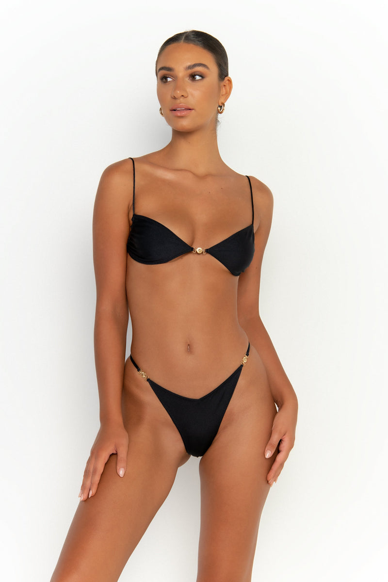 front view elegant woman wearing luxury swimsuit from sommer swim - lia nero is a black bikini with brazilian bikini bottom