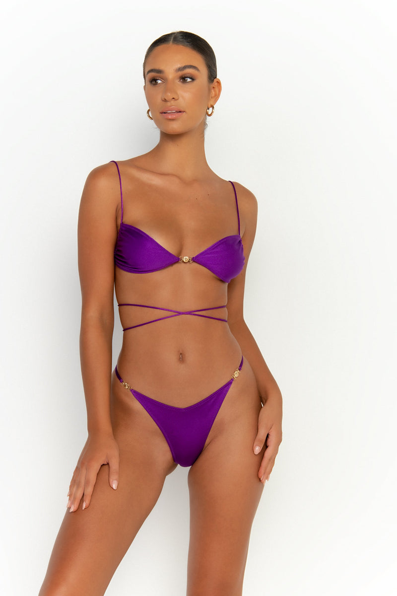 front alternative view elegant woman wearing luxury swimsuit from sommer swim - lia petunia is a purple bikini with brazilian bikini bottom