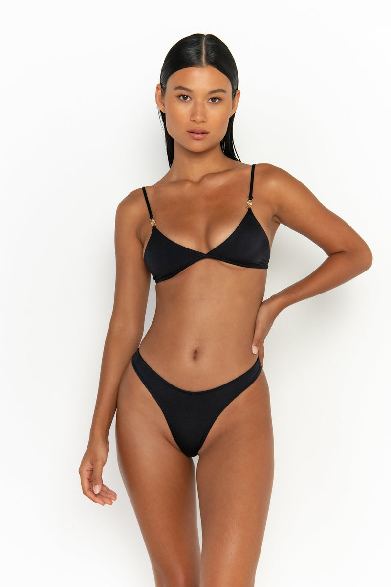 front view elegant woman wearing luxury swimsuit from sommer swim - niam nero is a black bikini with thong bikini bottom