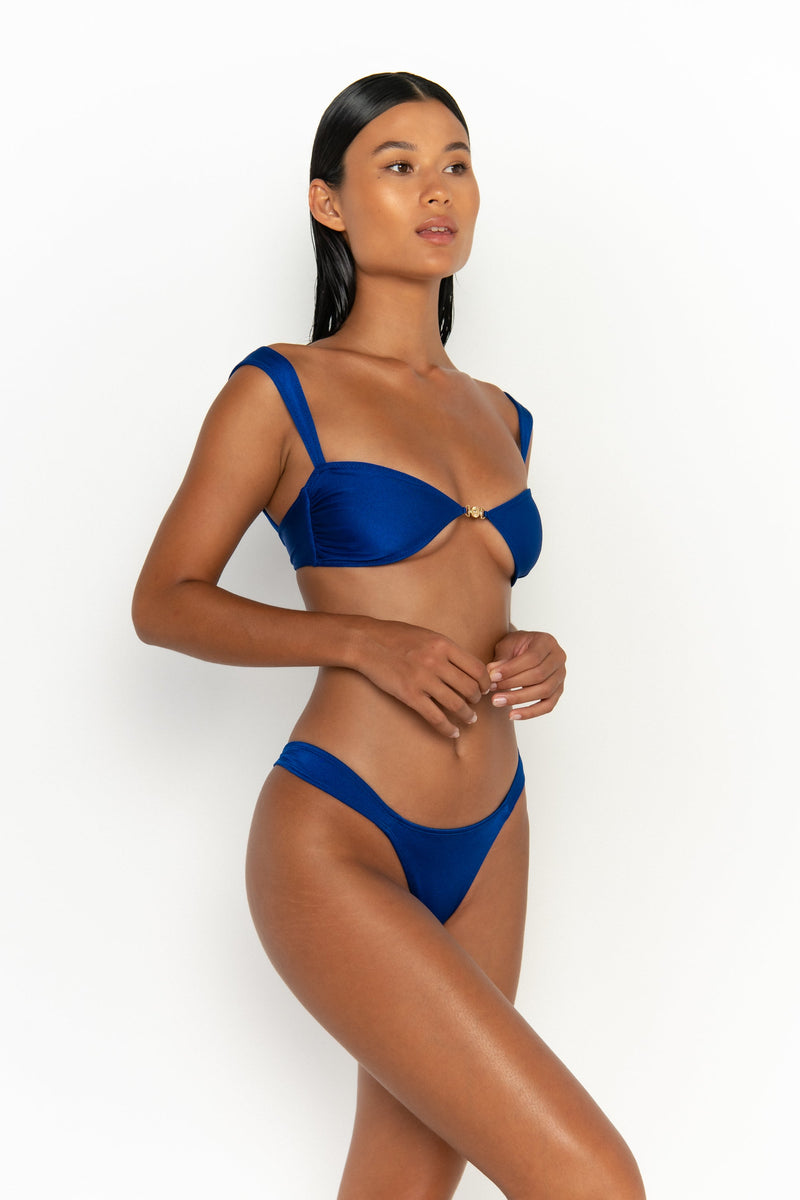 side view elegant woman wearing luxury swimsuit from sommer swim - soriya olympus is a royal blue bikini with balconette bikini top