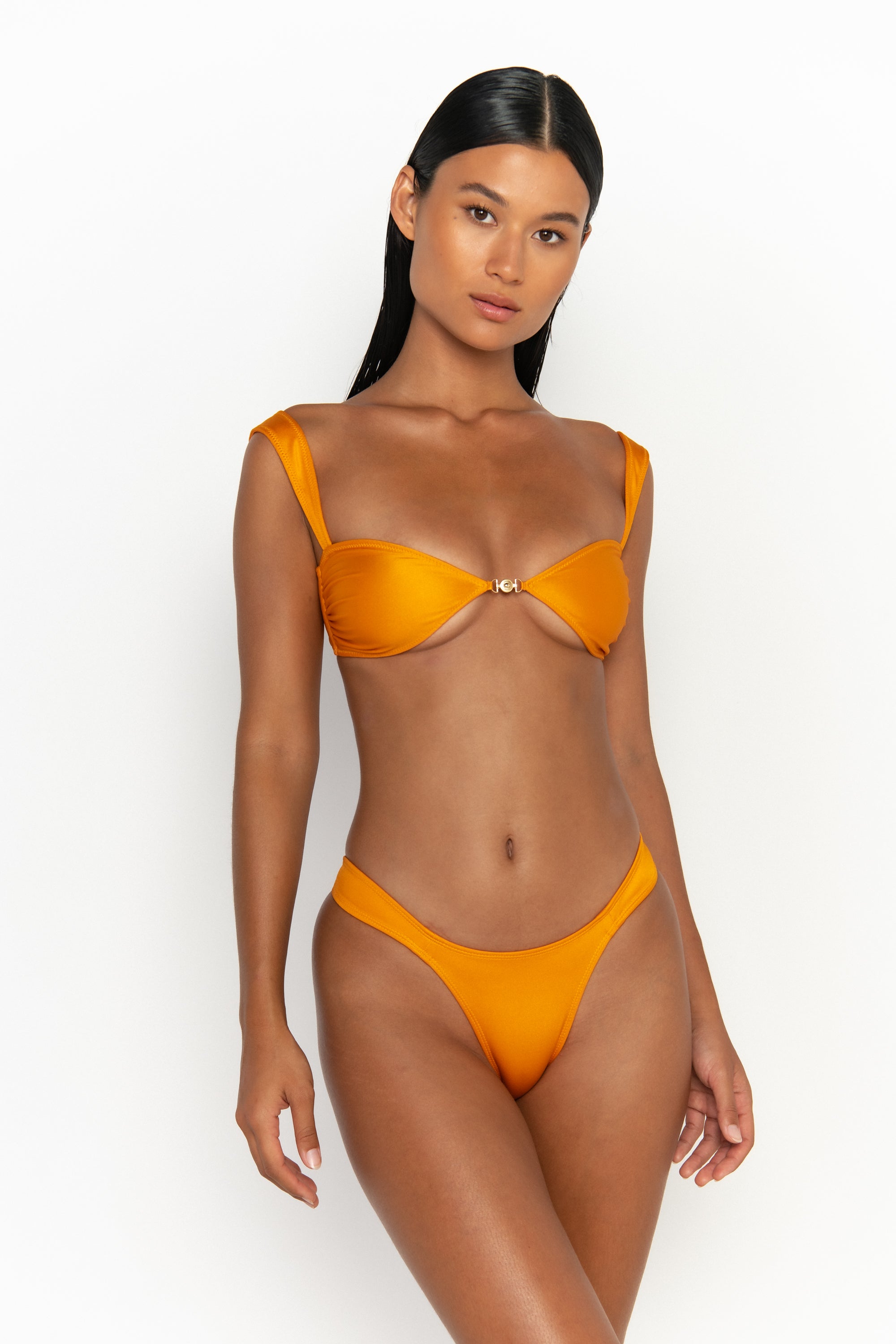 front view elegant woman wearing luxury swimsuit from sommer swim - soriya turmeric is a light orange bikini with balconette bikini top