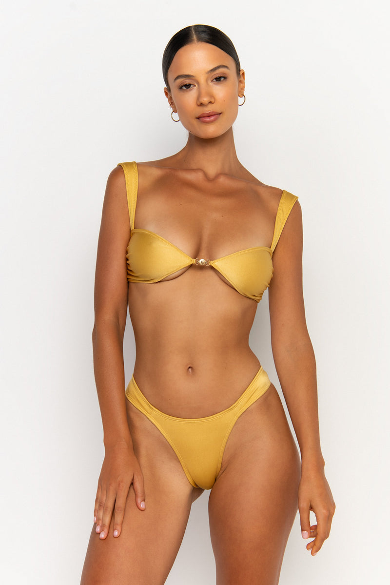 front view elegant woman wearing luxury swimsuit from sommer swim - zita lusso is a golden bikini with cheeky bikini bottom
