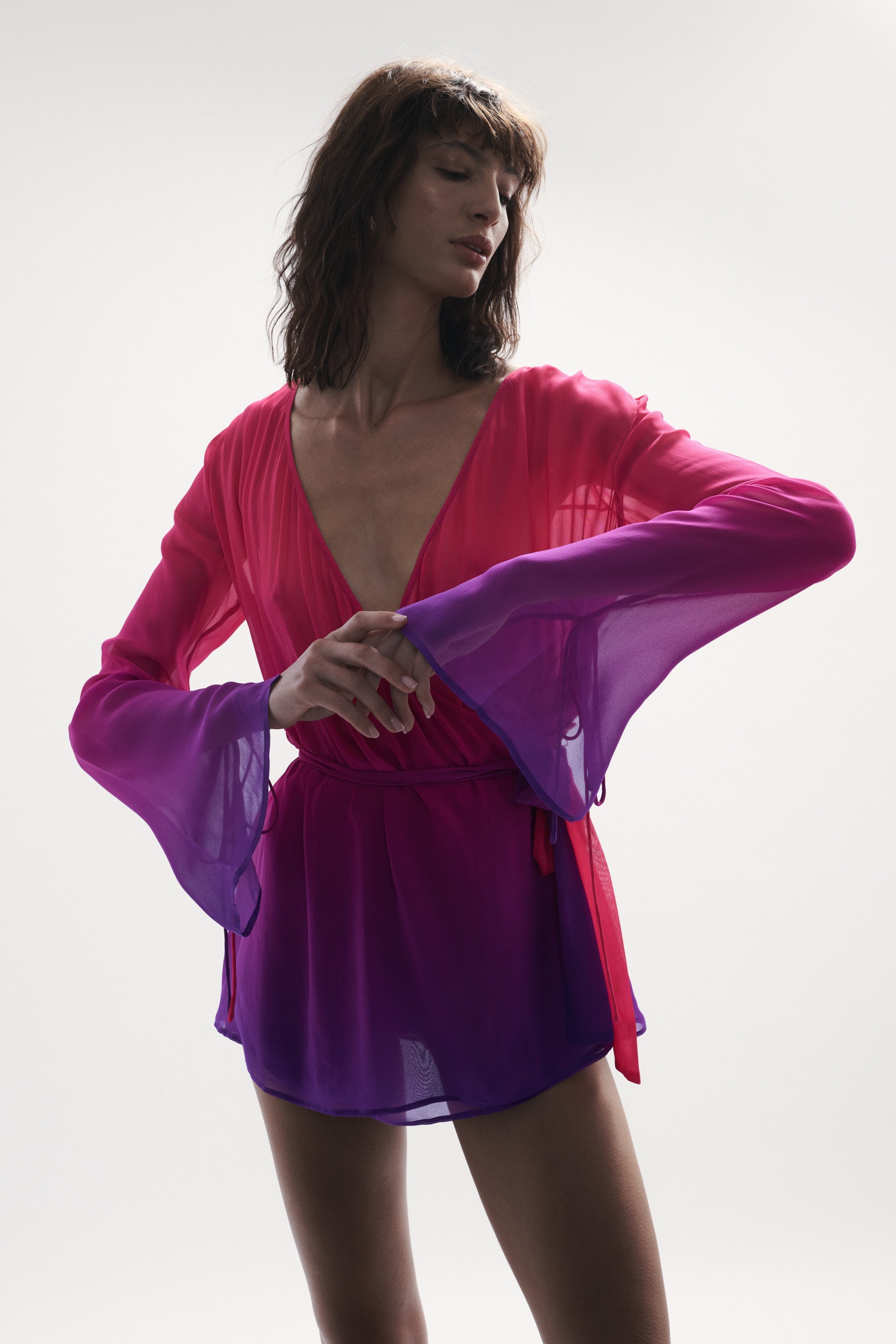 front side view elegant woman wearing luxury swimwear from sommer swim - palma berry crush is a wrap dress in pink and purple gradient color