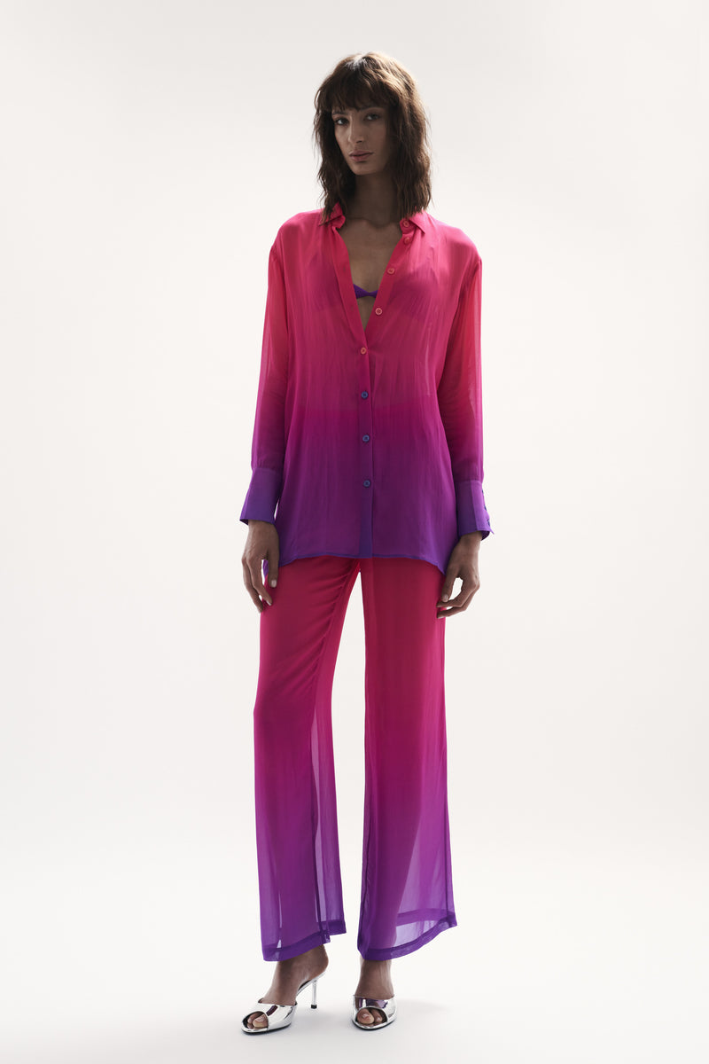 front view elegant woman wearing luxury resort wear from sommer swim - havana berry crush is a pink and purple shirt displayed fully outfit with pants
