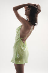 side view elegant woman wearing luxury resort wear from sommer swim - ibiza chartreuse is a light green sequin mini dress