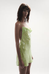 side view elegant woman wearing luxury resort wear from sommer swim - ibiza chartreuse is a light green sequin mini dress