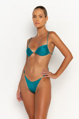 side view elegant woman wearing luxury swimsuit from sommer swim - lia blue fondale is an aqua blue bikini with brazilian bikini bottom
