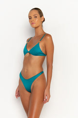 side view elegant woman wearing luxury swimsuit from sommer swim - niam blue fondale is an aqua blue bikini with thong bikini bottom