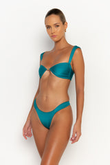 side view elegant woman wearing luxury swimsuit from sommer swim - zita blue fondale is an aqua blue bikini with cheeky bikini bottom