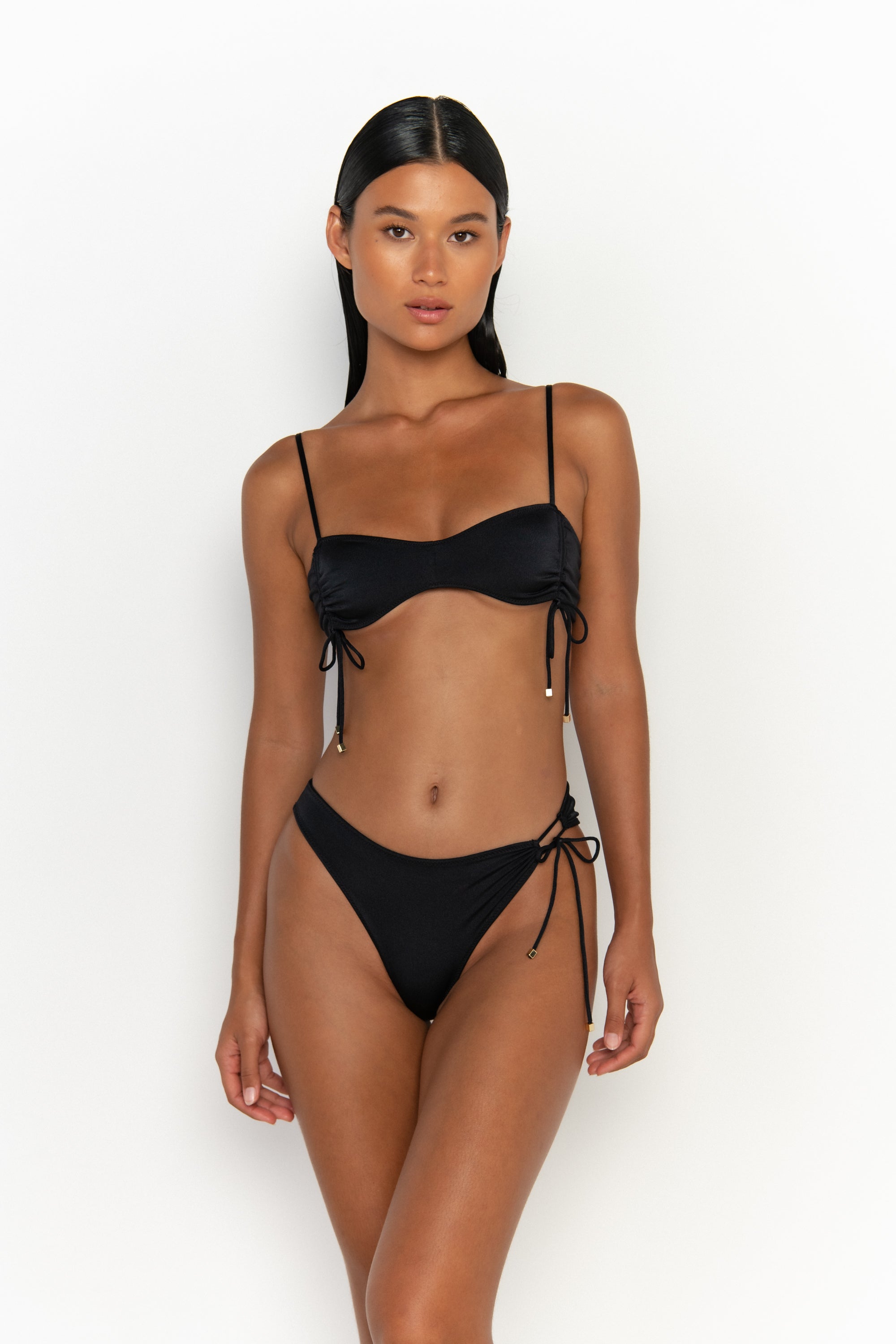 front view elegant woman wearing luxury swimsuit from sommer swim - bea nero is a black bikini with bralette bikini top