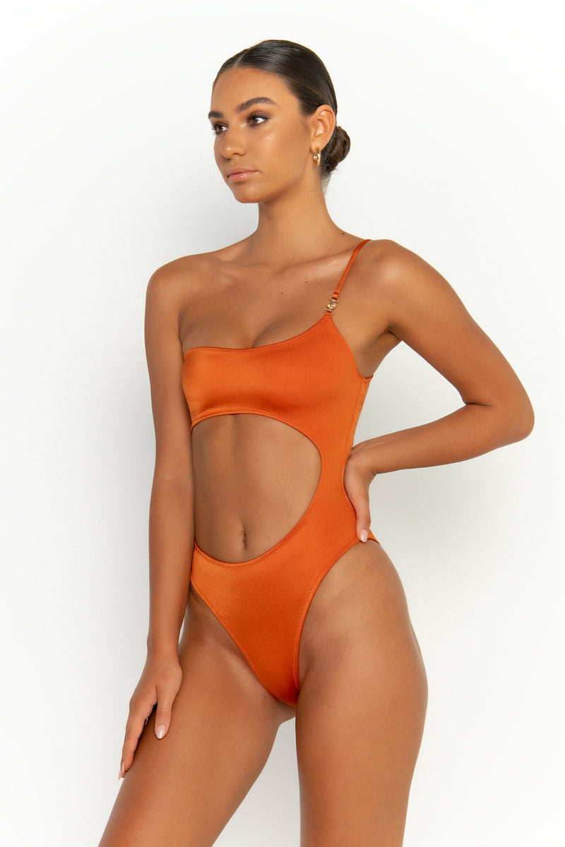 side view elegant woman wearing luxury swimsuit from sommer swim - bonita egitto is an dark orange one piece one shoulder swimsuit