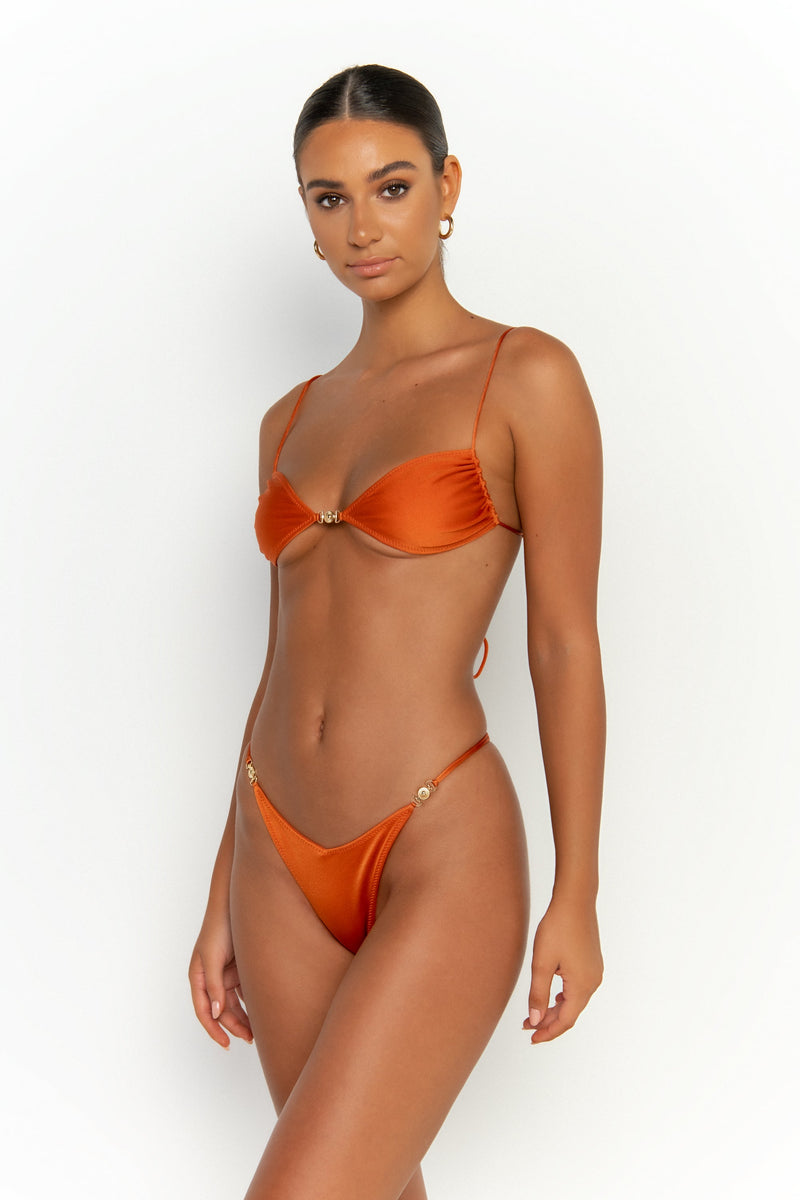 side view elegant woman wearing luxury swimsuit from sommer swim - ella egitto is a dark orange bikini with bralette bikini top