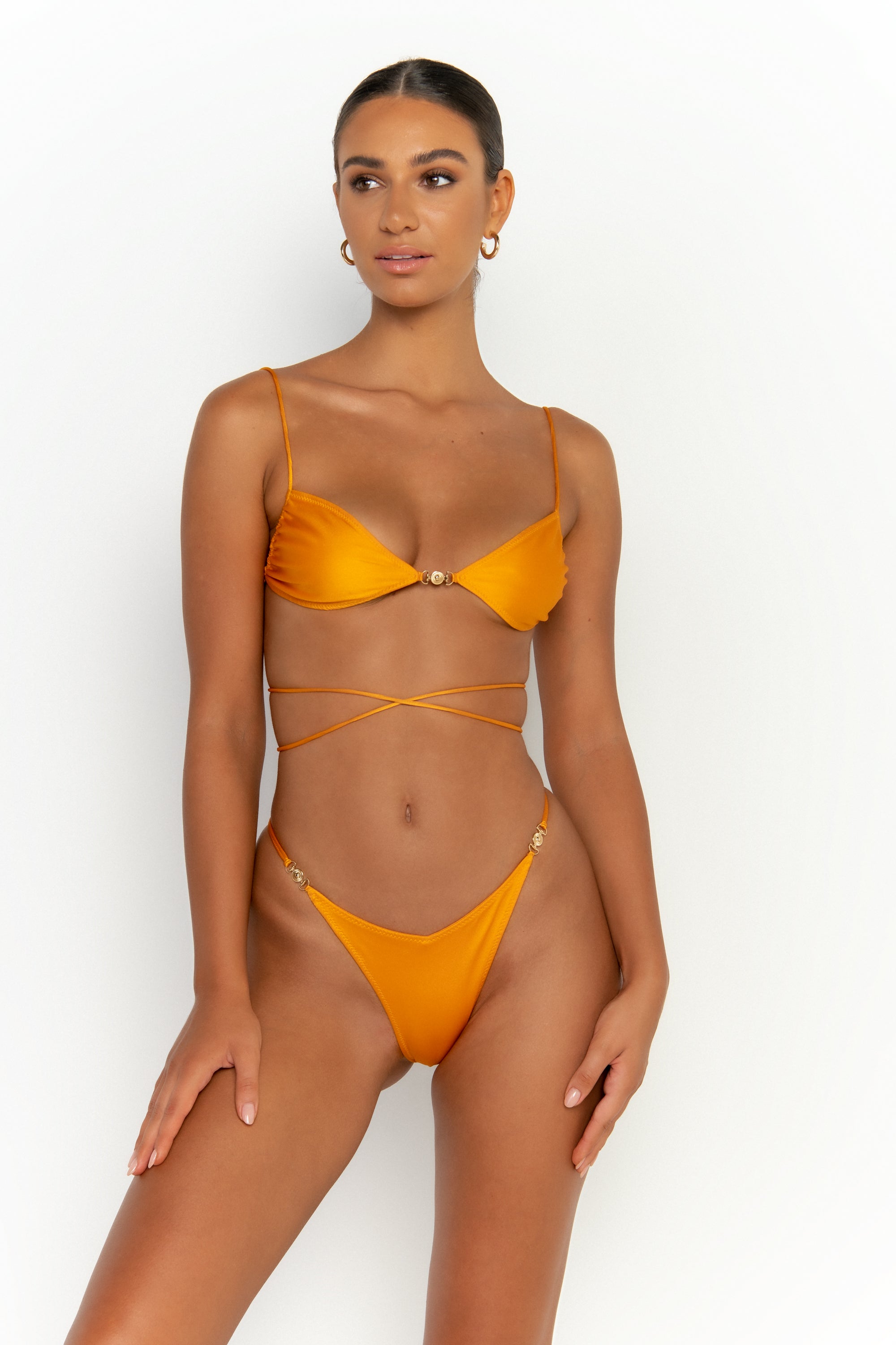 front view elegant woman wearing luxury swimsuit from sommer swim - ella turmeric is a light orange bikini with bralette bikini top