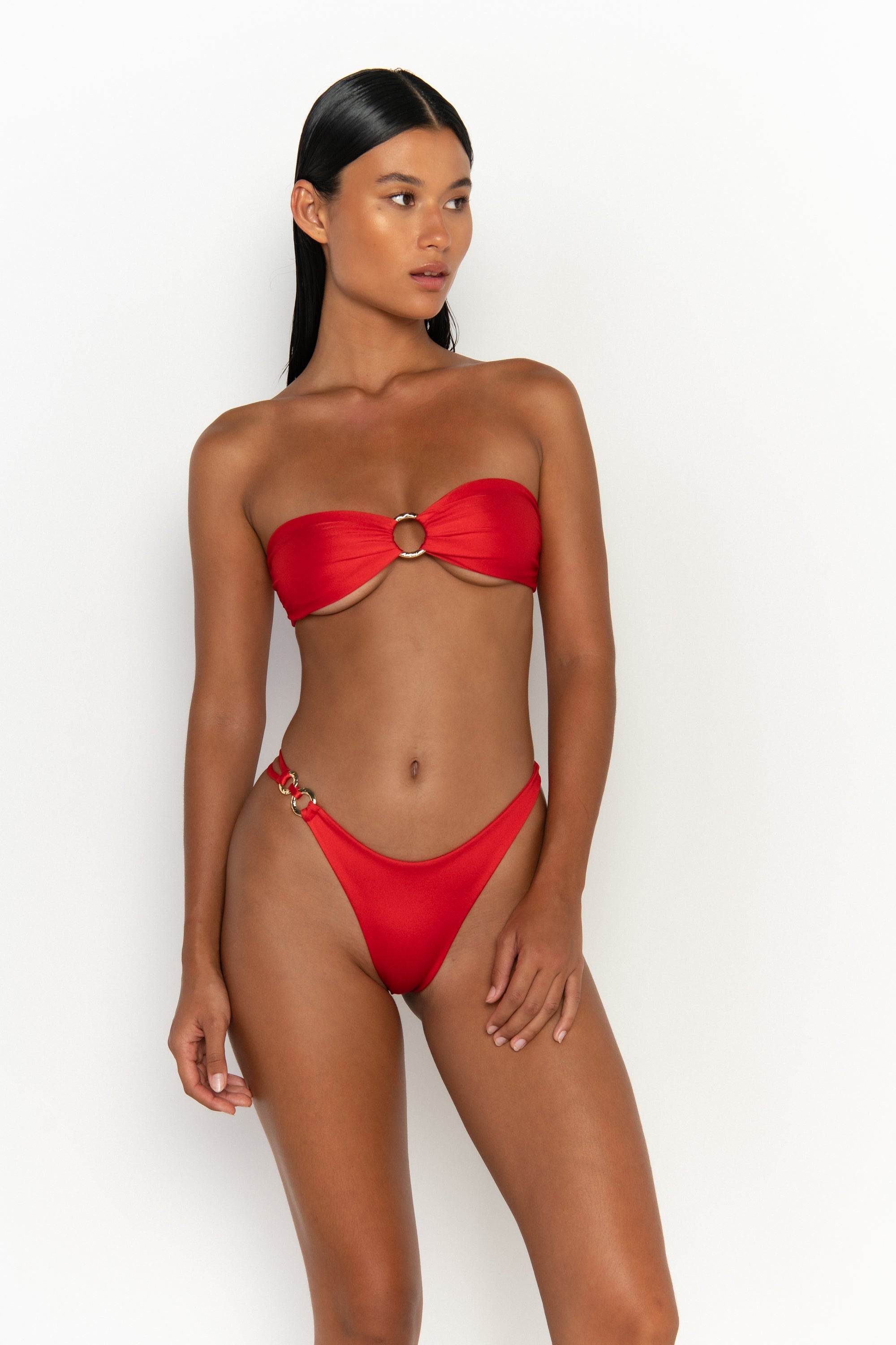 front view elegant woman wearing luxury swimsuit from sommer swim - cece siren is a red bikini with a bandeau bikini top