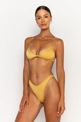 side view elegant woman wearing luxury swimsuit from sommer swim - juliet lusso is a golden bikini with bralette bikini top