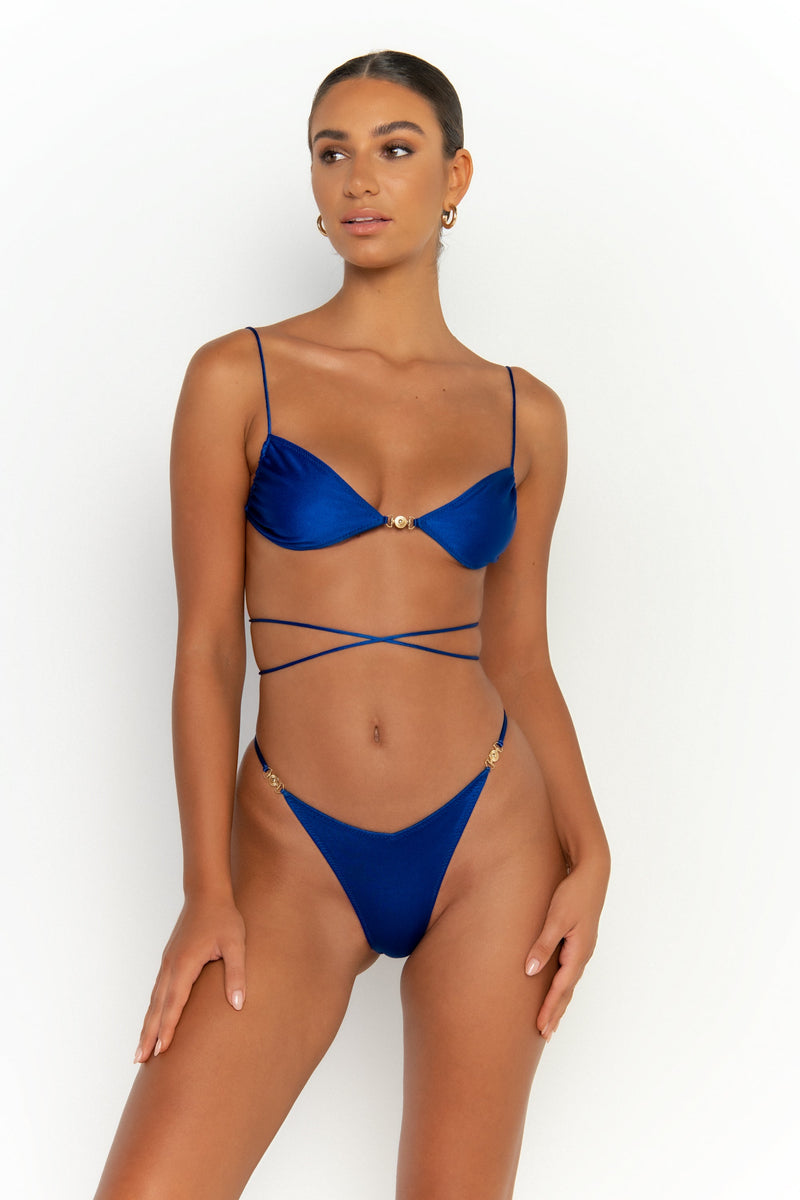 front alternative view elegant woman wearing luxury swimsuit from sommer swim - lia olympus is a royal blue bikini with brazilian bikini bottom