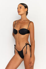 side view elegant woman wearing luxury swimsuit from sommer swim - paloma nero is a black bikini with tie side bikini bottom